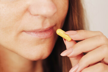 Woman about to take a pill at home. Daily medication routine for health and wellness....