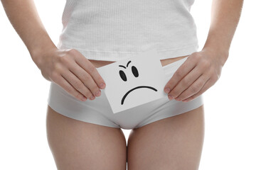 STD (sexually transmitted disease). Woman holding sticky note with drawn sad face on white...