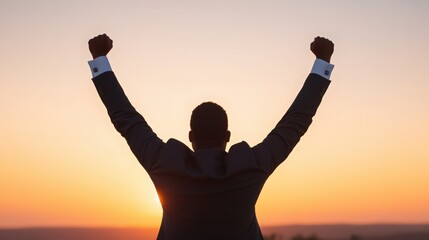 Fototapeta premium A man in a suit is standing in the sun with his arms raised in the air