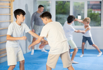Sedulous underage practitioner of self-defense courses applying attack methods on his opponent