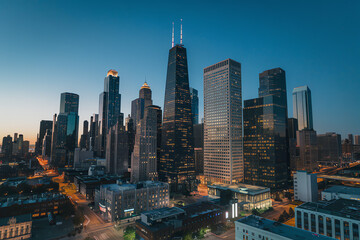 Naklejka premium Skyline of a bustling city illuminated at dusk, showcasing modern architecture and vibrant city life
