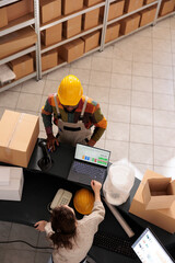 Top view of diverse team discussing customer order preparing packages for delivery in warehouse....