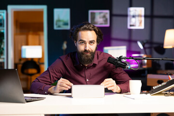 Tech guru filming packaged product unboxing for technology vlog, giving reasons to purchase it. Influencer recording video urging fans to buy sponsoring partner merchandise