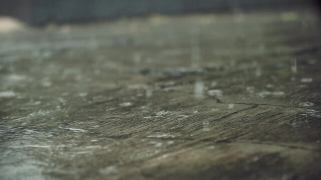 Rain water drops on concrete floor, slow motion video of rainy day.