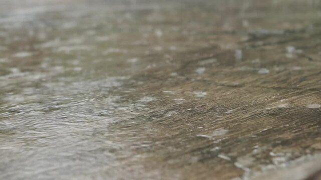 Rain water drops on concrete floor, slow motion video of rainy day.