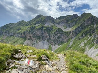 Fototapeta premium Mountaineering signposts and markings on the slopes of the Melchtal alpine valley and in the Uri Alps mountain massif, Kerns - Canton of Obwalden, Switzerland (Kanton Obwald, Schweiz)