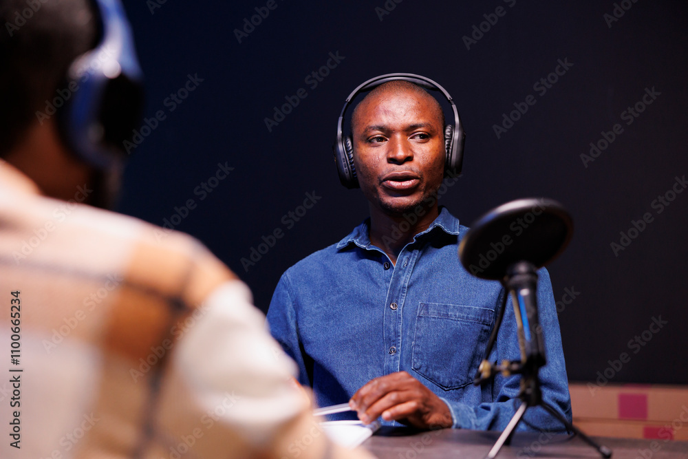 Poster black guy guest speaks into microphone, addressing questions from radio program host. african americ