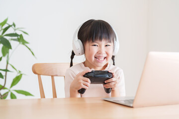 ノートパソコンでテレビゲームをする子供