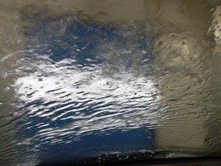 At the car wash. Water flows on the car window during washing. A clean car