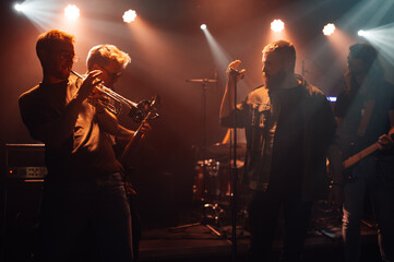 Musicians playing instruments and singing on stage during concert