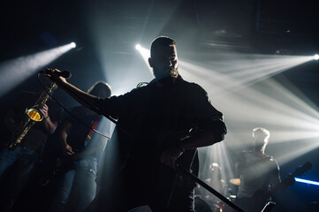 Singer performing with microphone on stage with band