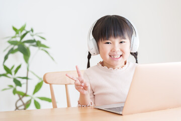 パソコンでオンラインレッスンを授業を受ける子供