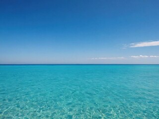 Fototapeta premium A serene ocean background with crystal clear turquoise water and a cloudless blue sky, perfect for travel websites and environmental designs, seascape, peaceful