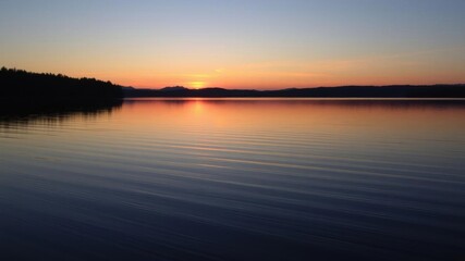 Obraz premium A serene photo of a tranquil lake at dusk, with the water reflecting the colors of the setting sun, tranquil, scenery
