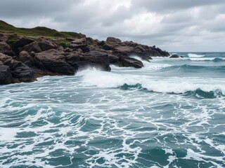 Fototapeta premium Rhythmic ocean waves crashing against rocky shoreline under cloudy skies, movement, power