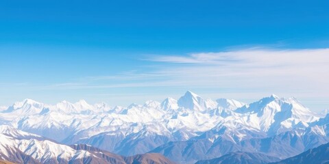 Fototapeta premium A breathtaking panoramic view of the snow-capped Nepal mountain range under a clear blue sky, showcasing towering peaks and dramatic valleys, scenic landscape, geography