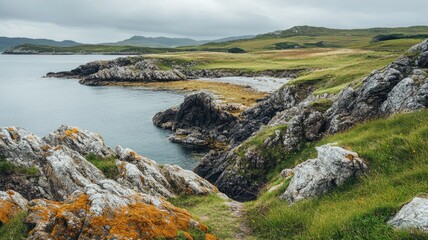 Rocky coastline with green hills and calm water under cloudy sky