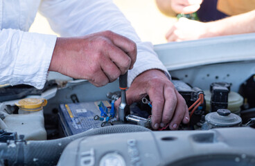 Man hands working in the car engine mechanic close up