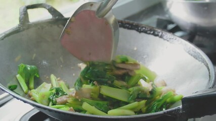 Slow motion footage of cooking, stir-frying vegetables in a pan in the kitchen. Fresh, organic green vegetables that help maintain the body. Garden vegetables. Cooking with heat. Video menu for lunch 