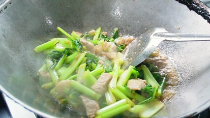 Slow motion footage of cooking, stir-frying vegetables,pig in a pan in the kitchen. Fresh, vegetables with meat that help maintain the body. Garden vegetables. Cooking with heat. Video menu for lunch 