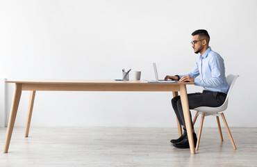 Profile Side View Portrait Of Focused Middle Eastern Male Manager In Glasses Working On Laptop...