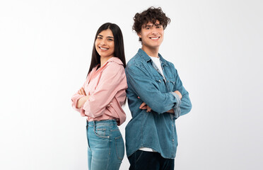 Cheerful Young Couple Crossing Hands In Confident Gesture Smiling To Camera Standing Back To Back...