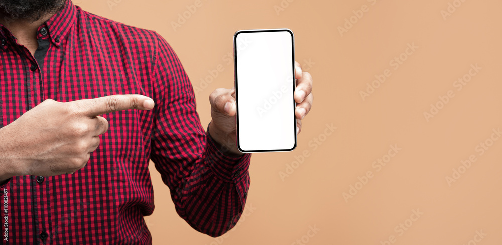 Aufkleber Choose This Cellphone. Closeup of unrecognizable african american man holding smartphone with white blank screen in hand and pointing at it, showing empty space for mock up, yellow background