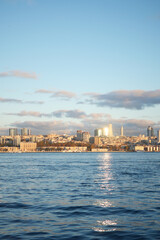 A picturesque city skyline beautifully reflected on calm waters during a stunning sunset