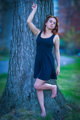 beautiful woman in a black dress, barefoot in a forest