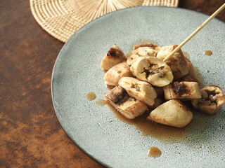 Thai grilled banana slice with caramel coconut sauce with wooden stick