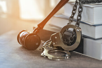 Fetters and wooden gavel with the sunrise background, Litigation or re-litigation between plaintiff and defendant ,the judgement must be justic for accused. Unjust can turn their world upside down.