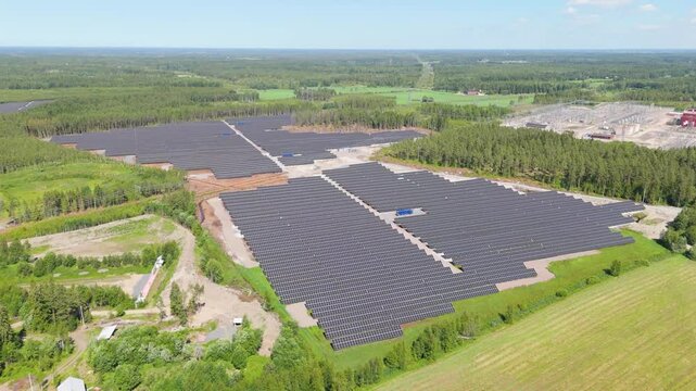 High aerial panoramic overview of bifacial panels at Solar Farm in Finland showcasing energy production in middle of forest and field cleared for development