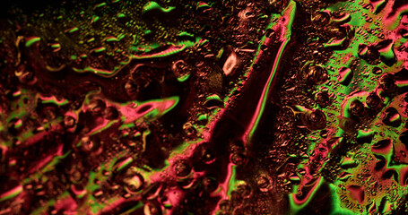 Foil liquid. Wet surface. Colored streams on iridescent glass. Spectrum light in water changing...