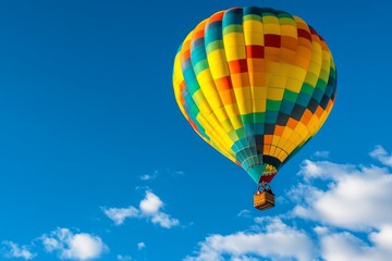 Obraz premium A hot air balloon soaring against a clear blue sky, with colorful patterns standing out vividly