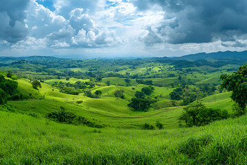 Obraz premium Breathtaking Panoramic View of Lush Green Rolling Hills and Dramatic Sky