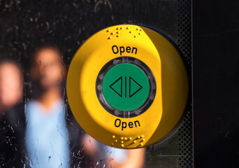 Button for controlling door opening in a bus standing at a stop