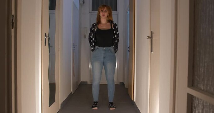 Beautiful sexy and creepy girl showing 2 swords in the dark hallway, full shot