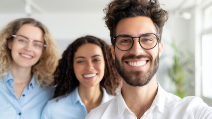 Fototapeta premium Smiling young man with glasses taking a selfie with his cheerful friends in a bright and casual indoor setting