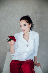 Portrait of a beautiful fashionable woman with a red rose