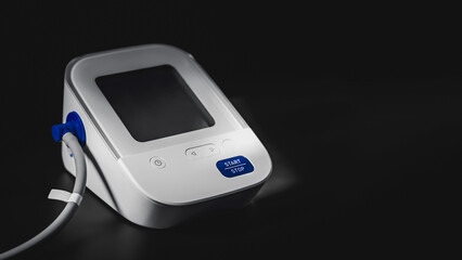 Digital blood pressure monitor with dark copyspace background. Home medical equipment.