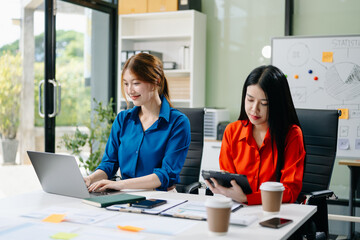 Asian business colleague business presents and explains and using laptop and tablet. Teamwork,...