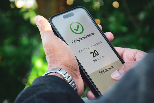 Man got a congratulatory message on his mobile phone earning points by shopping online. Modern marketing strategy loyalty program for customer engagement.