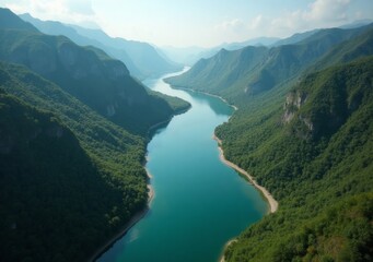 Fototapeta premium Stunning river winding through lush green mountains under a clear blue sky