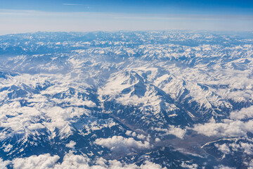 Fototapeta premium clouds and snow covered alp mountains from sky