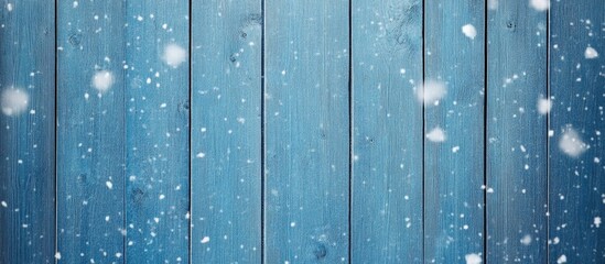 Blue wooden planks with snowflakes on a winter background creating a cozy and serene seasonal atmosphere
