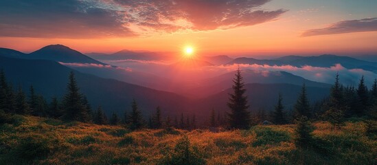 Obraz premium Serene sunrise over mountains with lush greenery and mist creating a tranquil atmosphere for a perfect camping holiday experience