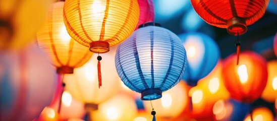Obraz premium Colorful lanterns illuminating the night sky at a festive celebration creating a warm and inviting atmosphere