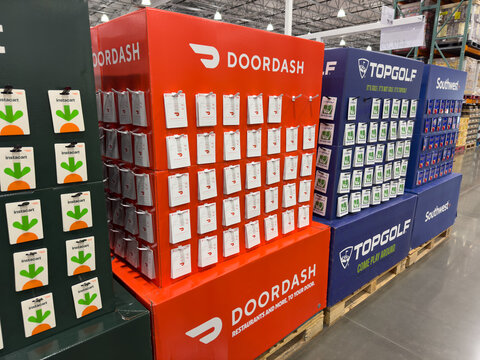 Big gift card stands inside Costco warehouse full of Doordash and Top Golf cards.