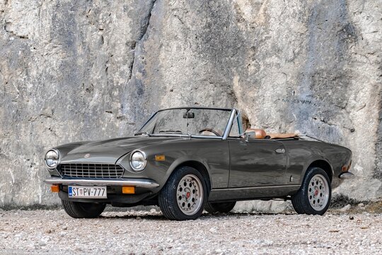Omis, Croatia - August 31st, 2023 - Legendary classical Fiat Spyder on the road. One of the longest-lived Fiats, 124 Sport Spider was styled in 1966 by Pininfarina design studio and sold until 1985.