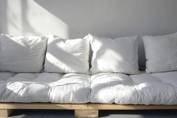 Minimalistic morning sunlight on white cushions in a serene indoor setting